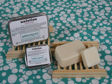 Load image into Gallery viewer, unlotion solid lotion bars in both small 0.6 ounce and large 2 ounce sizes with labeled metal hinged tins